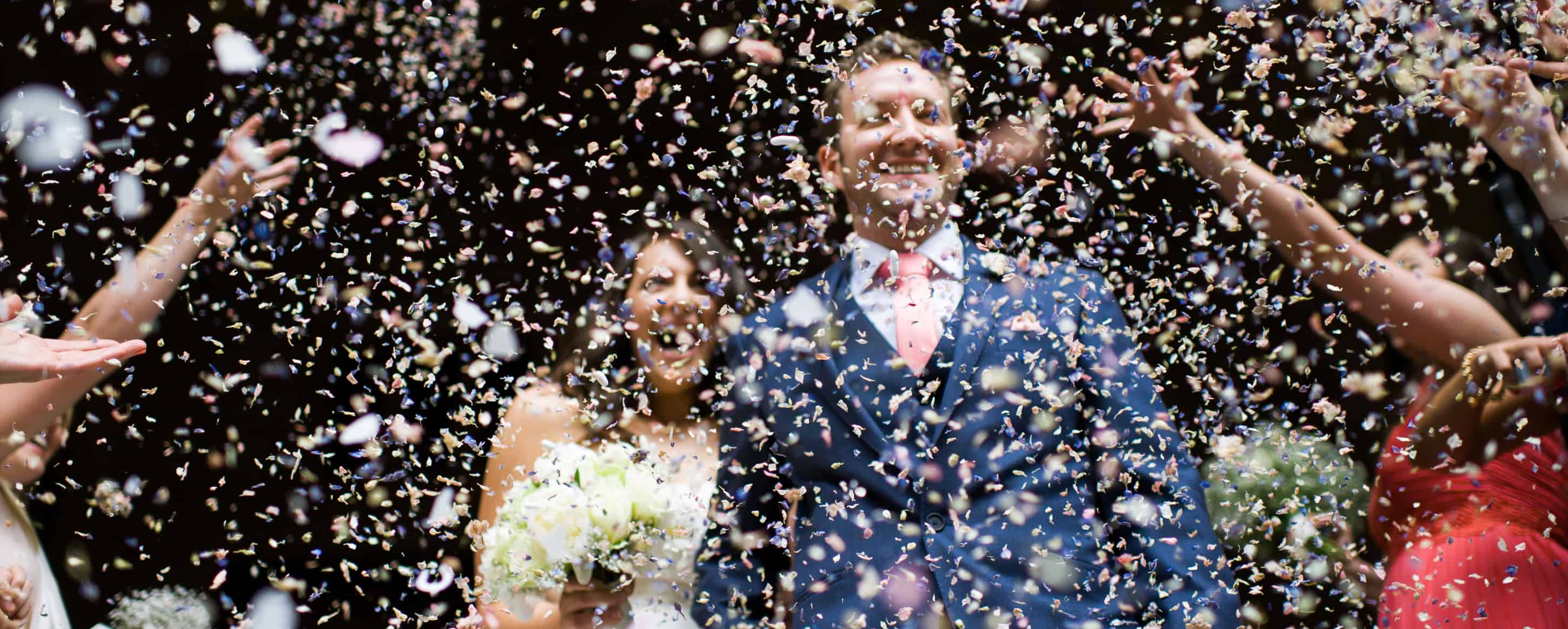 Andrew and Sarah under wedding confetti